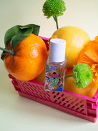 Nature Insolente Eau de Parfum – farbenfrohe Glasflasche mit weißem Sprühkopf, pinker Korb, Zitrusfrüchte – Parfüm