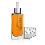 Kjaer Weis The Beautiful Oil – transparente Glasflasche mit Pipettenverschluss, orangefarbenes Öl, weißer Hintergrund – Hautpflege