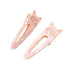 Katze Oval Saltwater Pink – pink cat-shaped hair clips with gold accents on white background – hair styling