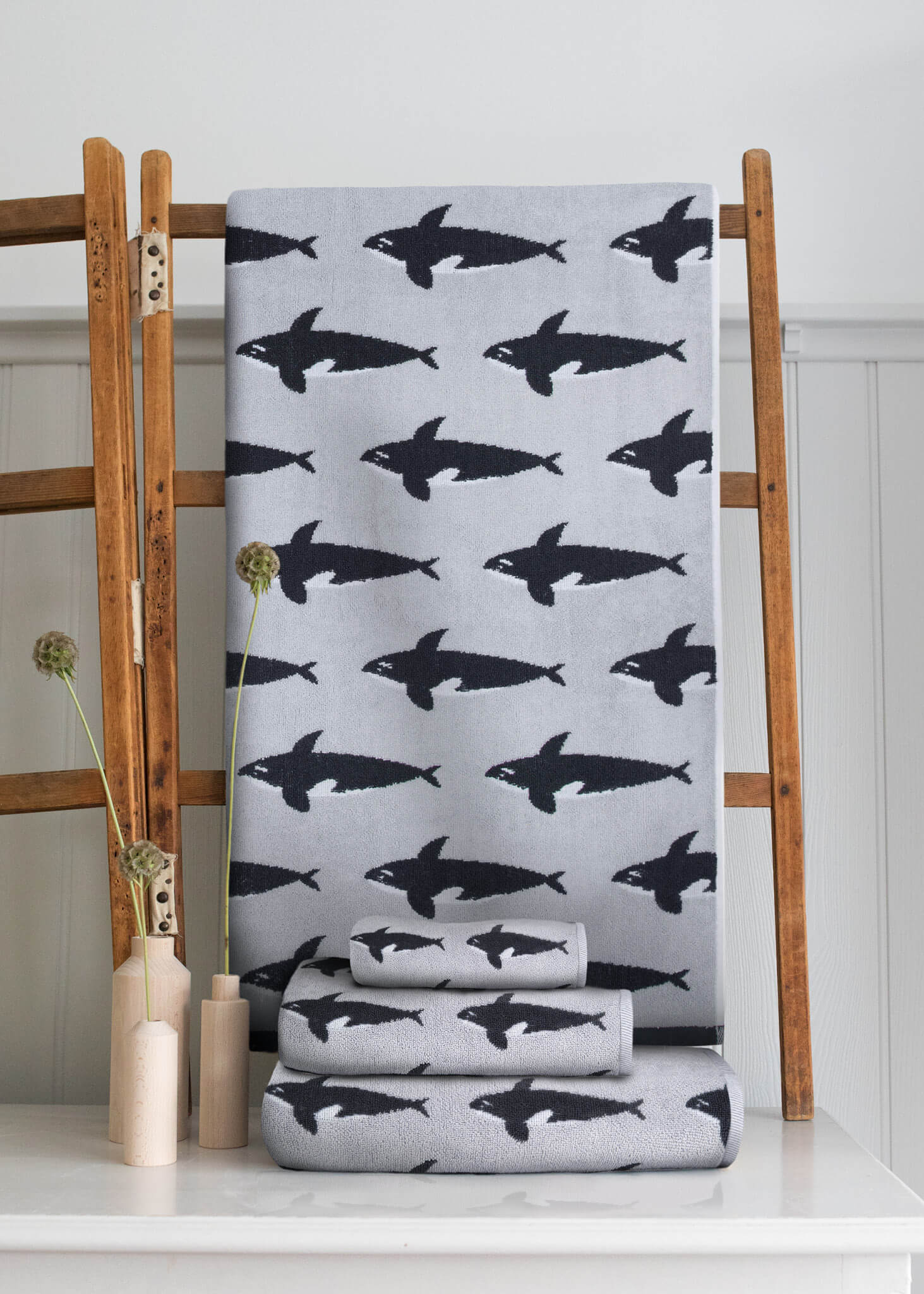 Orca Organic Cotton Waschlappen – grau mit schwarzen Orcas, auf Holzleiter, weißer Hintergrund – Hautpflege
