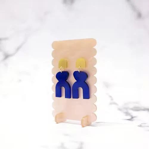 Translucence II – blaue Ohrringe mit gelben Akzenten auf cremefarbenem Display, marmorierter Hintergrund – Schmuck