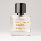 Un Deux Trois Soleil Eau de Parfum – klares Glasfläschchen mit schwarzem Deckel, weißem Hintergrund – Parfüm