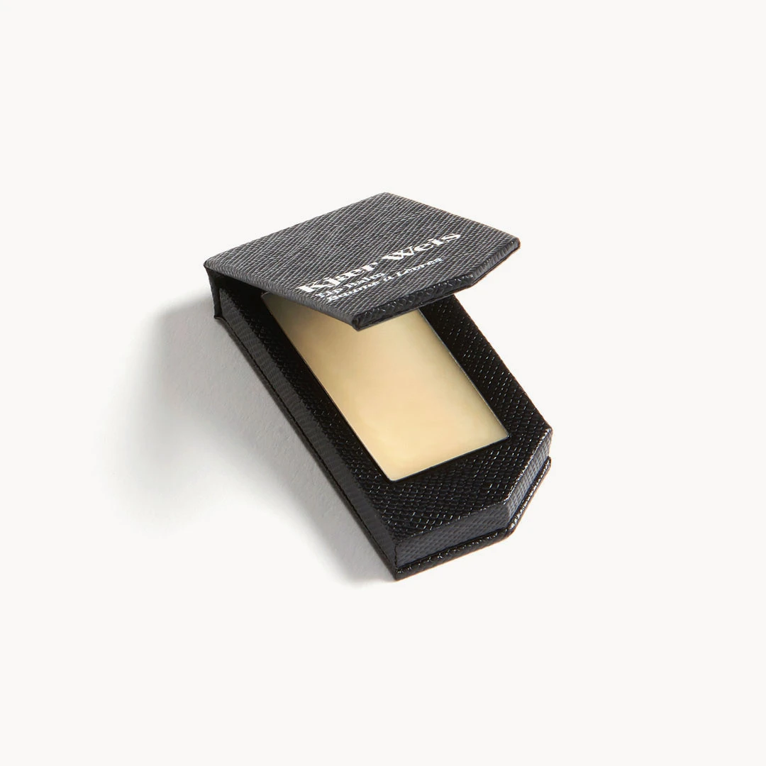 Kiehl's Black Edition Lip Balm – black textured box, cream-colored balm, white background – lip care