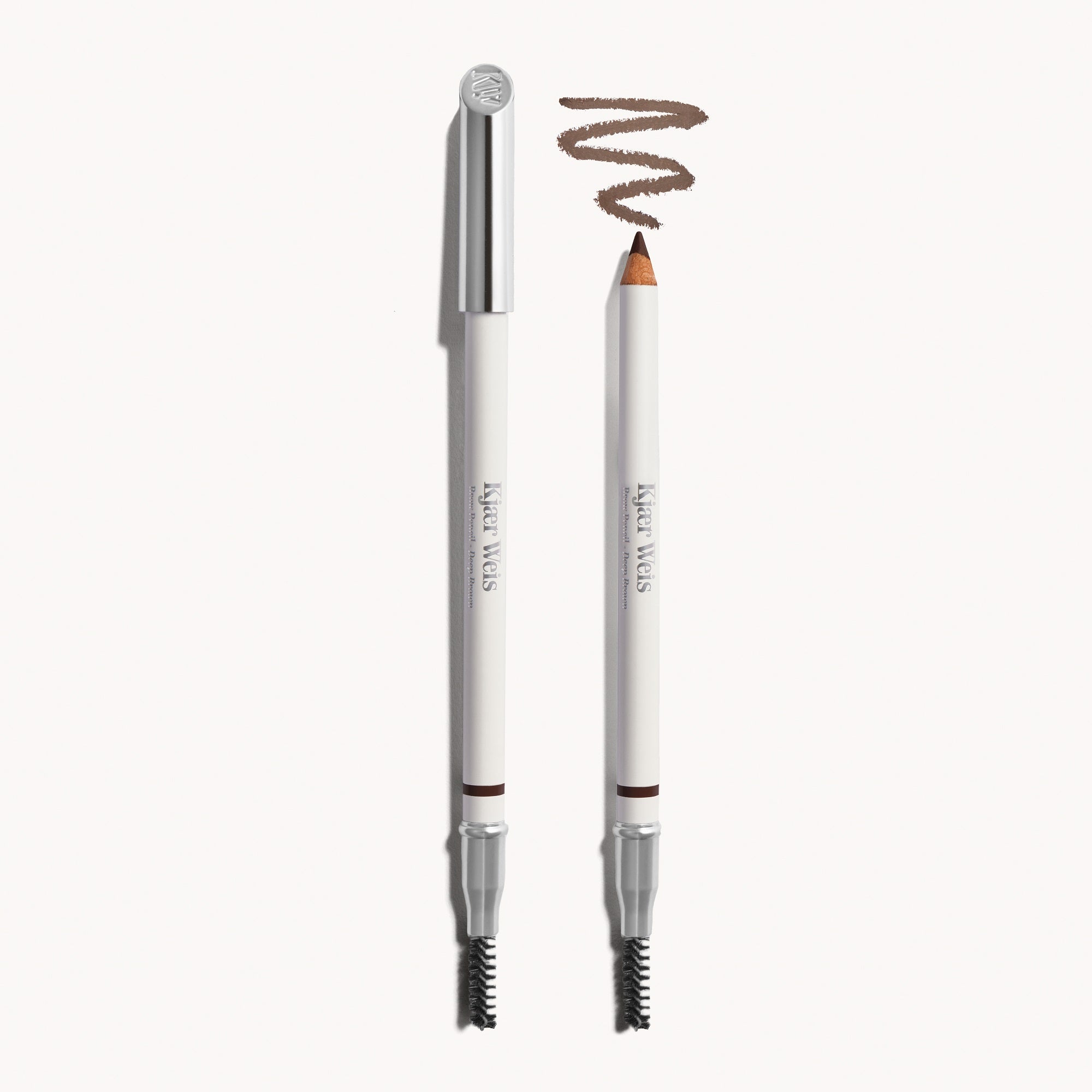 Kjaer Weis Augenbrauenstift – weißer Stift mit silbernem Deckel, Farbe Deep Brown, cremefarbener Hintergrund – Augenbrauenstyling