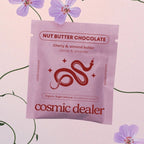 Cosmic Dealer Nut Butter Chocolate – purple pouch with cherry almond butter, pink floral background – snack