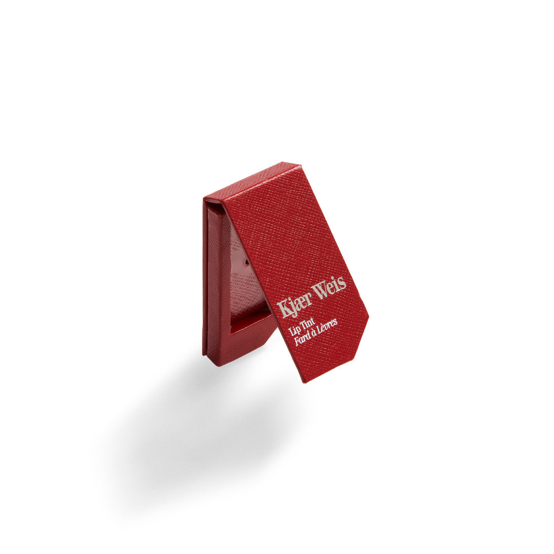 Kjaer Weis Lip Tint Verpackung – rote Texturbox mit weißer Schrift, weißer Hintergrund – Lippenpflege