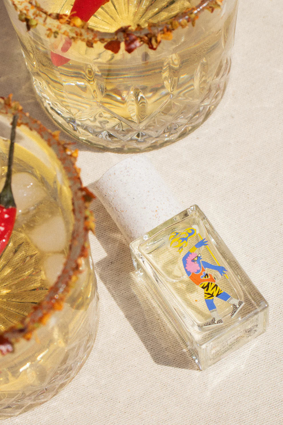 Ukhu Pacha Eau de Parfum – klares Glasfläschchen mit buntem Etikett, weißem Korkverschluss, cremefarbenem Hintergrund – Parfüm
