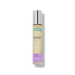 The Organic Pharmacy Brightening Plus Serum in einer Glasflasche mit silbernem Verschluss auf weißem Grund, Hautpflege