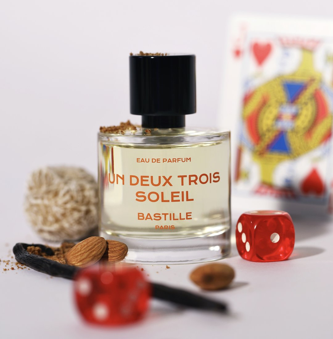 Un Deux Trois Soleil Eau de Parfum – klares Glasflakon mit schwarzem Deckel, weißer Hintergrund – Parfüm