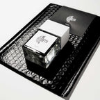 Je Ne Regrette Rien Parfum – square glass bottle with white cap, black background – perfume