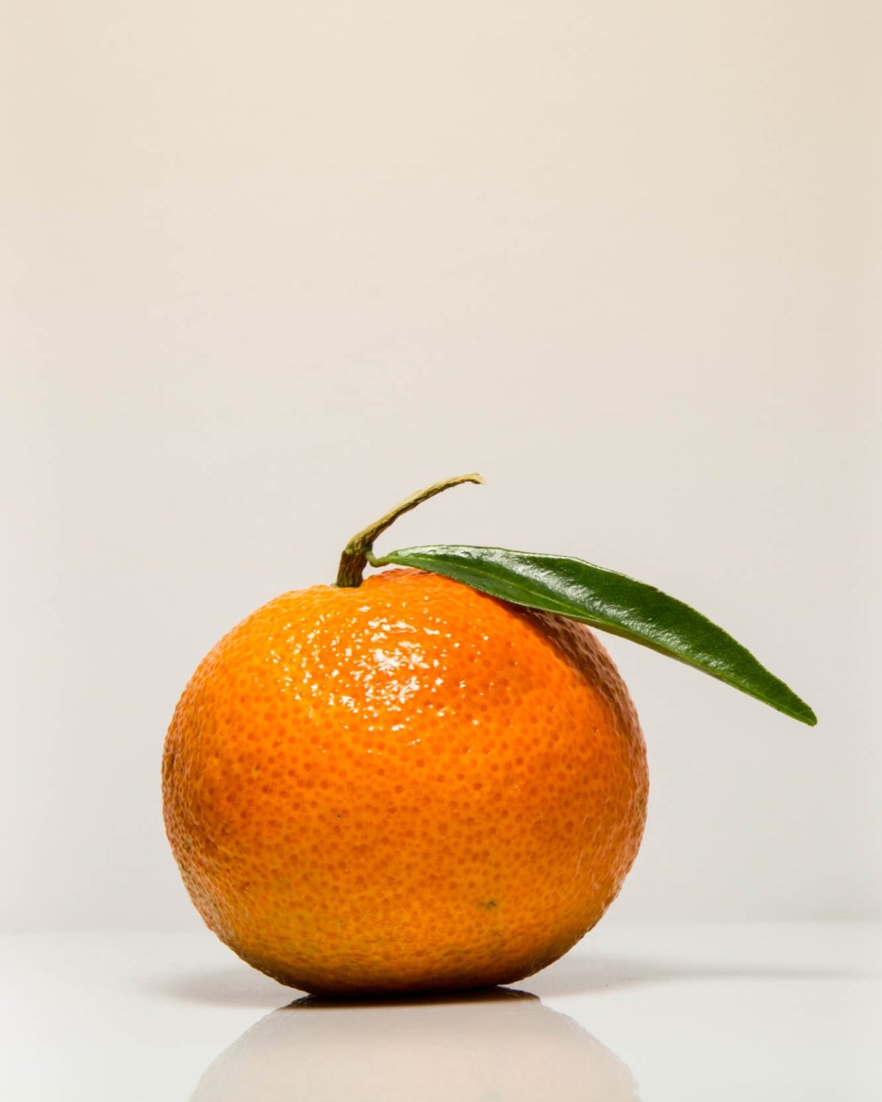 Smoothiebody Bath Red Mandarin – frische Mandarine mit grünem Blatt auf weißem Hintergrund – Körperpflege