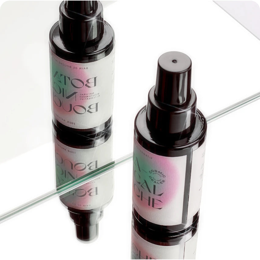 Botanical Bouche Mundspülung – dunkle Sprühflasche mit schwarzem Zerstäuber, weißem Etikett und rosa-grünem Design, weißer Hintergrund – Mundpflege