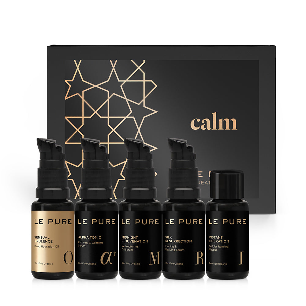 LE PURE Treatment Set Calm – fünf schwarze Pumpfläschchen vor schwarzem Geschenkkarton mit Goldmuster – Hautpflege