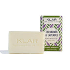 KLAR Festes Shampoo Teebaumöl & Lavendel – 100g, cremefarbene Seife mit Verpackung, weißer Hintergrund – Haarpflege