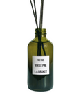 L:A Bruket No. 332 Winter Pine – green glass bottle with rattan reeds, white label on white background – room fragrance
