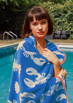 Lobster Blue Organic Cotton Beach Towel – blue with lobster print, woman by pool – beach accessories
