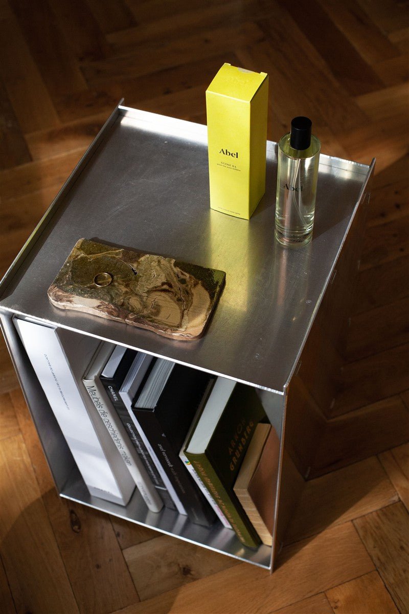 Abel Scene 01 Parfüm – klares Glasfläschchen mit schwarzem Verschluss, gelbe Verpackung, metallischer Hintergrund – Duft