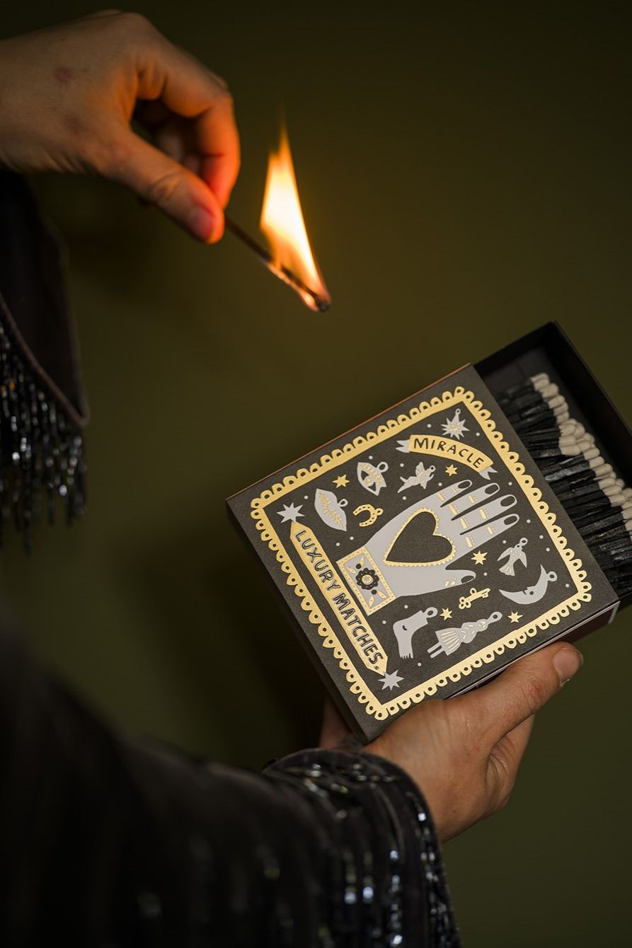 Black Miracle Luxury Streichhölzer – schwarze Schachtel mit goldener Verzierung, dunkler Hintergrund – Lifestyle