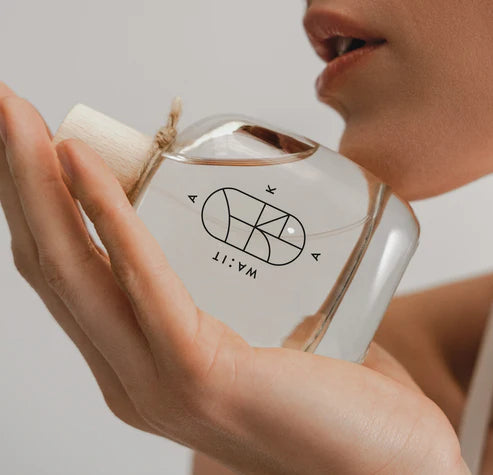 Aka Eau de Parfum – transparente Glasflasche mit Holzverschluss, weißer Hintergrund – Parfüm