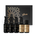 LE PURE Treatment Set Glow – fünf schwarze Fläschchen mit Pump- und Schraubverschluss, goldene Etiketten, schwarzer Hintergrund – Hautpflege