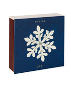 Winter Joy Geschenkbox – dunkelblaue Verpackung mit weißem Schneeflocken-Design, goldener Schrift, weißem Hintergrund – Hautpflege