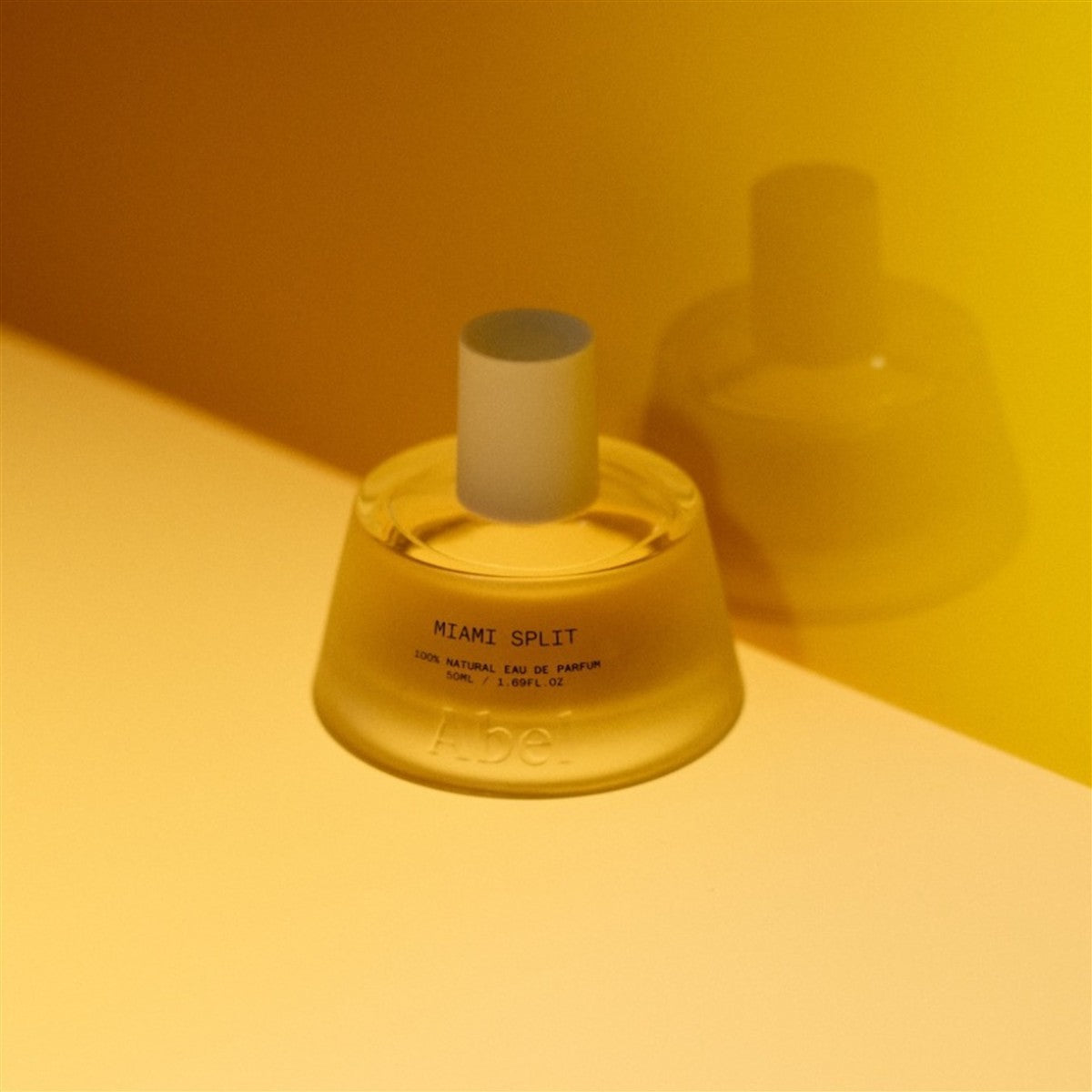 Abel Miami Split Eau de Parfum – clear glass bottle 50ml, white cylinder cap, yellow background – perfume