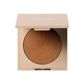 ILIA Daylite Highlighting Powder – beige Puderdose, goldener Glanz, weißer Hintergrund – Make-up