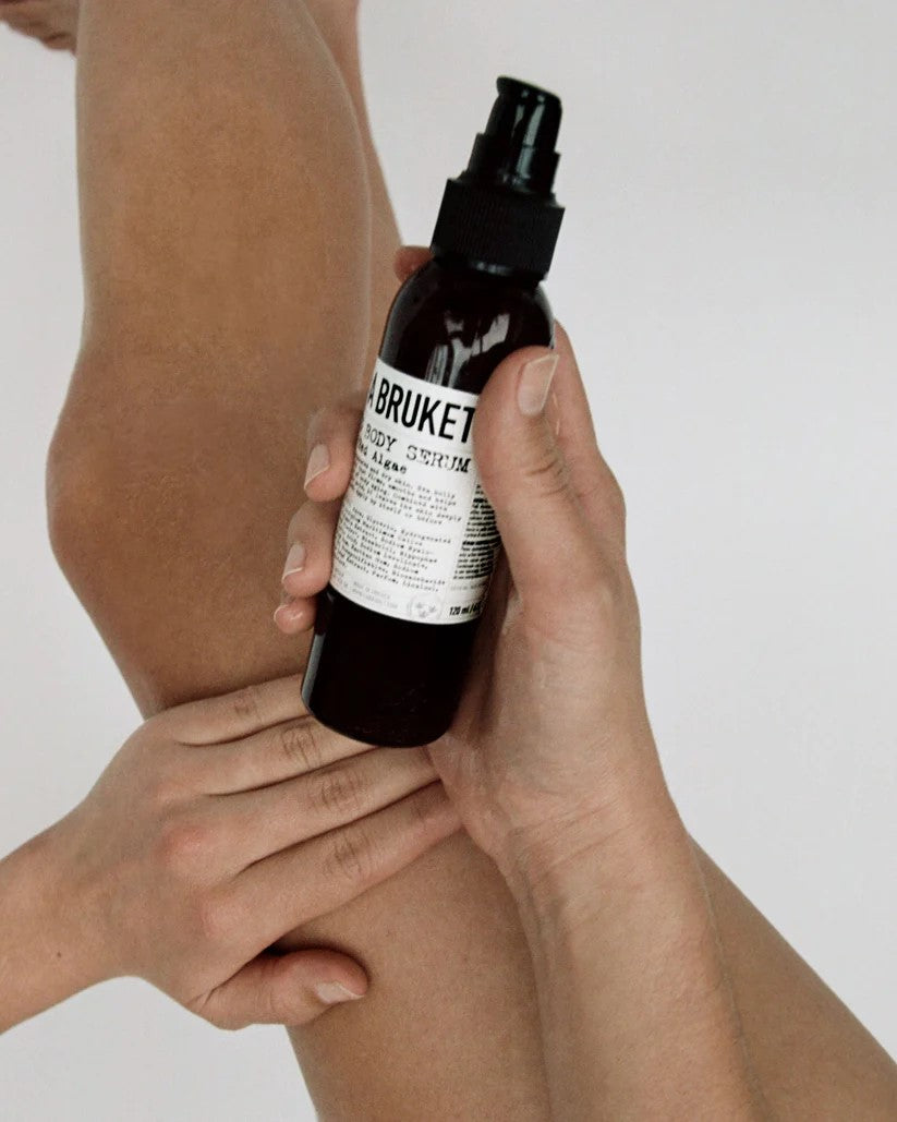 A BRUKET No. 290 Festigendes Körper-Serum – dunkle Glasflasche 120ml, schwarzer Sprühkopf, weißer Hintergrund – Hautpflege