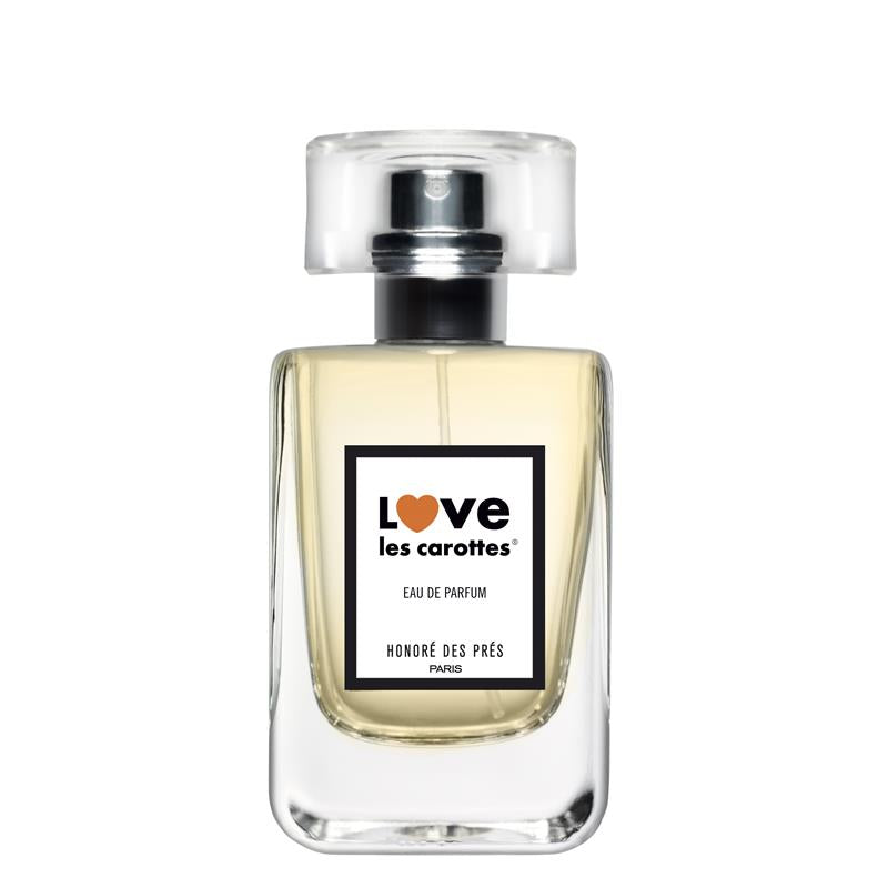 Love Les Carottes Eau de Parfum – klares Glasflakon mit Sprühkopf, weißem Etikett und orangefarbenem Herz, weißer Hintergrund – Parfüm