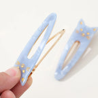 Katze Oval Hair Clip – light blue cat shape with gold accents, white background – hair styling