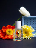 Lost in Translation Eau de Parfum – klares Glasfläschchen 15ml, weißer Sprühkopf, dunkler Hintergrund mit Blumen – Parfüm