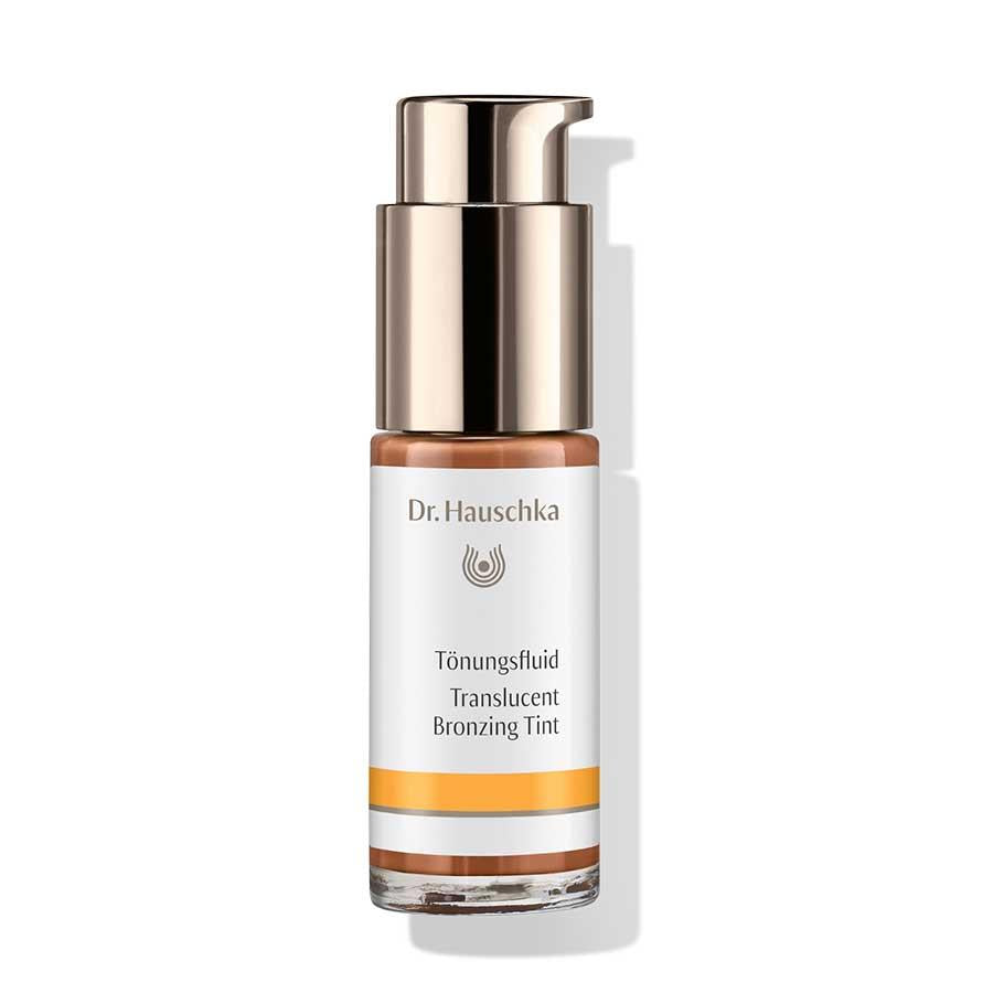 Dr. Hauschka Tönungsfluid – Glasflasche mit Pumpspender, weiß-orangem Etikett, weißem Hintergrund – Gesichtspflege