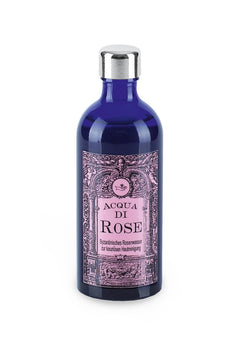 Aqua di Rose – dunkelblaue Glasflasche mit silbernem Deckel, rosafarbenes Etikett, weißer Hintergrund – Hautreinigung