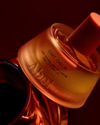 Abel Coat Check Perfume Bottle – 50ml, warm orange, pink spray cap, dark background – perfume