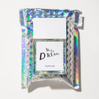 Wet Dreams Parfum – clear glass bottle with white cap, holographic background – perfume