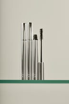 Holi(lash) Growth Mascara – silver tube with open cap, wand brush, cream background – lash care