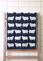 Sheep Organic Cotton Bath Towel – navy towel with white sheep, red border, on radiator – bathroom accessories