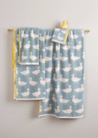 Waddling Ducks Organic Cotton Bath Towel – light blue towel with white ducks, yellow border, hanging on rod – bath textiles