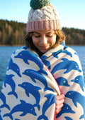 Jumping Dolphins Organic Cotton Beach Towel with blue dolphins, cream base and red border – beach accessory