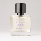 Pleine Lune Eau de Parfum – klares Glasfläschchen mit schwarzem Deckel, lila Schrift, weißem Hintergrund – Parfüm