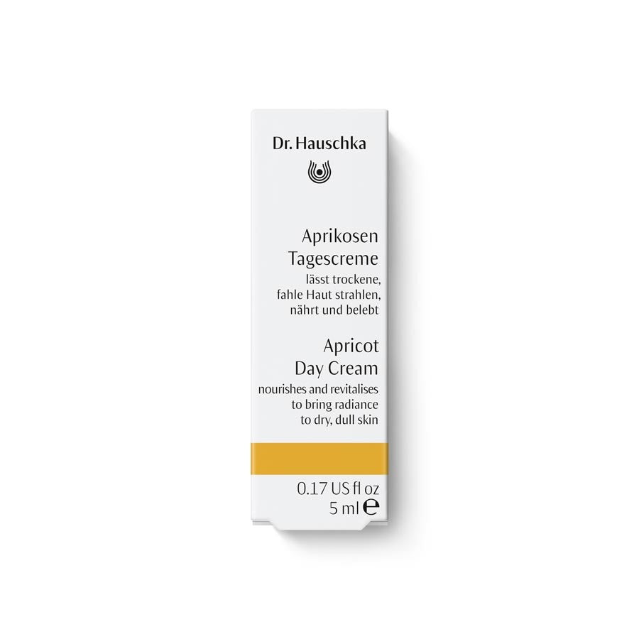 Dr. Hauschka Aprikosen Tagescreme – weiße Kartonverpackung 5ml, orangefarbener Streifen, weißer Hintergrund – Hautpflege