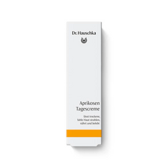 Dr. Hauschka Aprikosen Tagescreme – weiße Kartonverpackung mit orangefarbenem Streifen, weißer Hintergrund – Hautpflege
