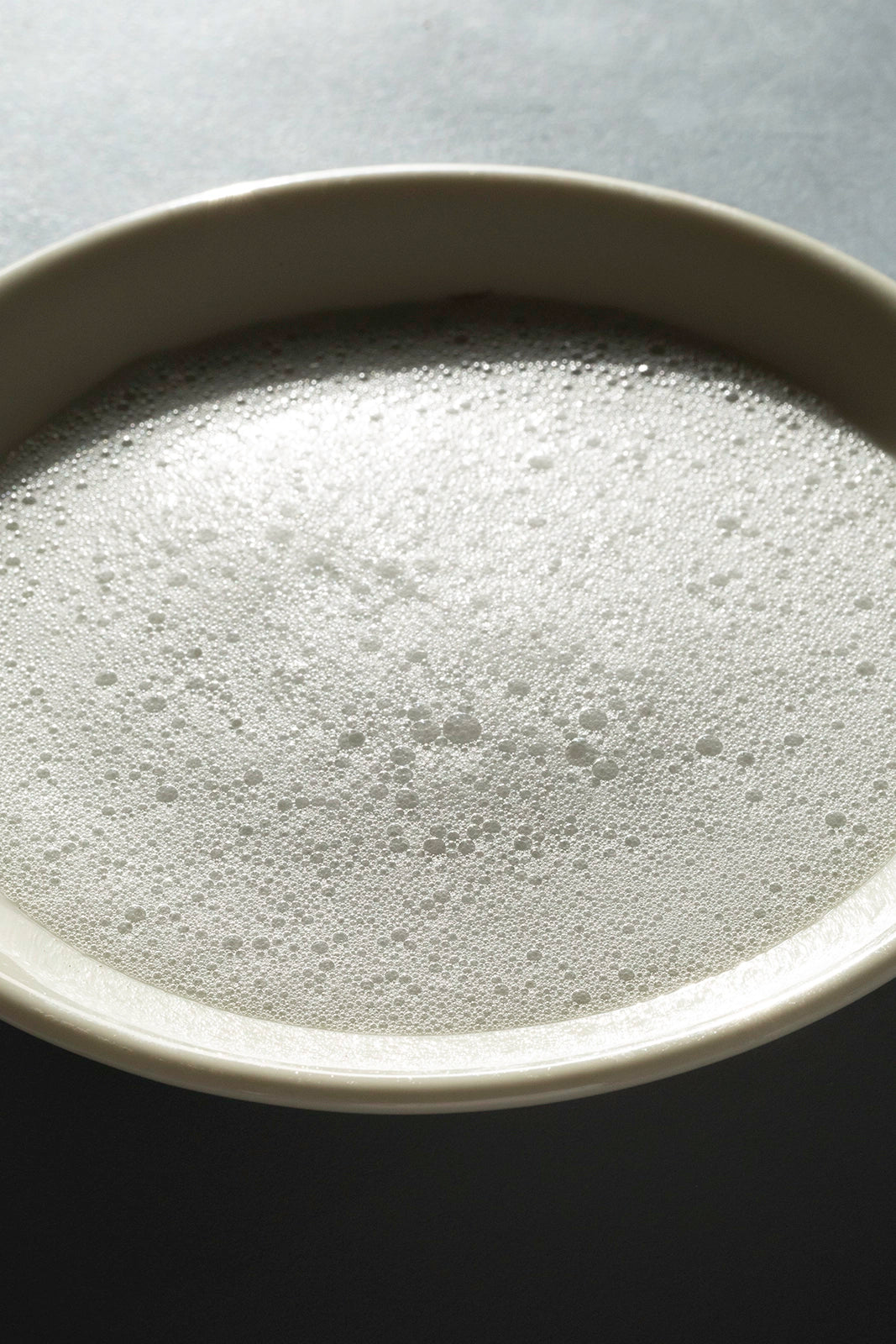 Smoothiebody Bath Urban Botanical – cremiger Schaum in weißer Schale, grauer Hintergrund – Körperpflege