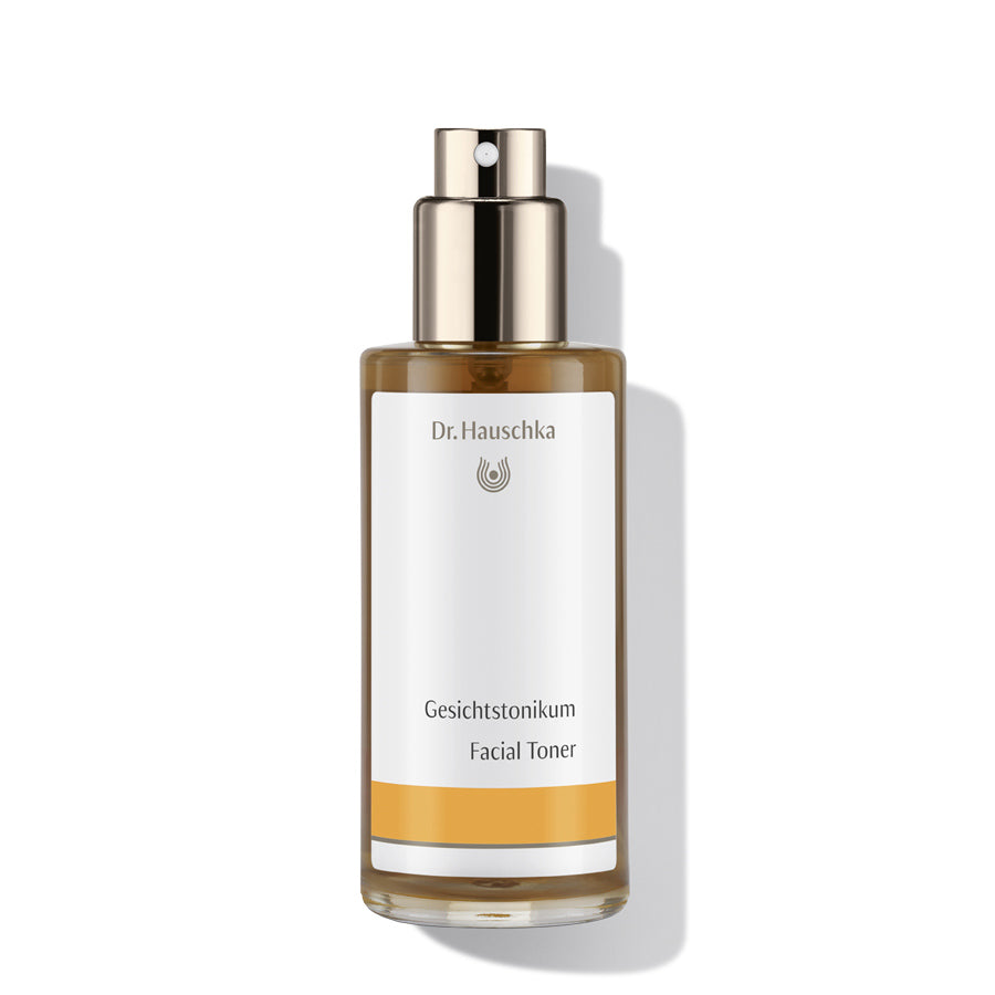 Dr. Hauschka Gesichtstonikum – braune Glasflasche mit Sprühkopf, weißem Etikett und orangefarbenem Streifen, weißer Hintergrund – Hautpflege