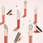 Lip Gloss Courage in pink glass tubes with silver caps on a light pink background for glossy lips.