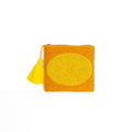 Clutch Medium Earth, eine orangefarbene, perlenbestickte Clutch mit gelbem Oval und gelber Quaste auf weißem Hintergrund.