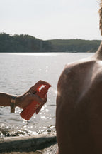Orange spray bottle with nozzle for Sunscreen Mist SPF 50 Body skin care by the sea.