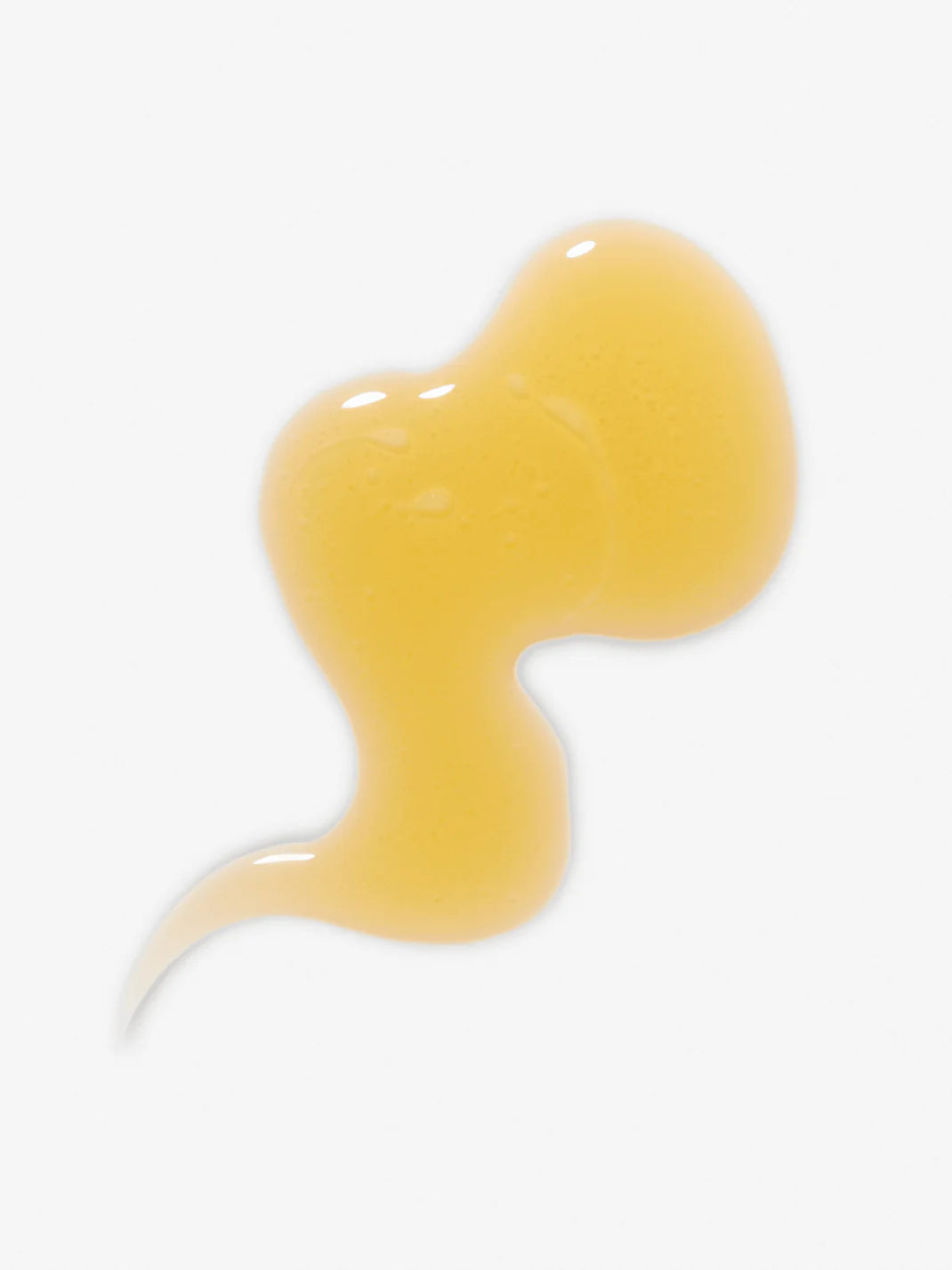 Gelber Tropfen des Face Oils auf weißem Hintergrund für die Hautpflege