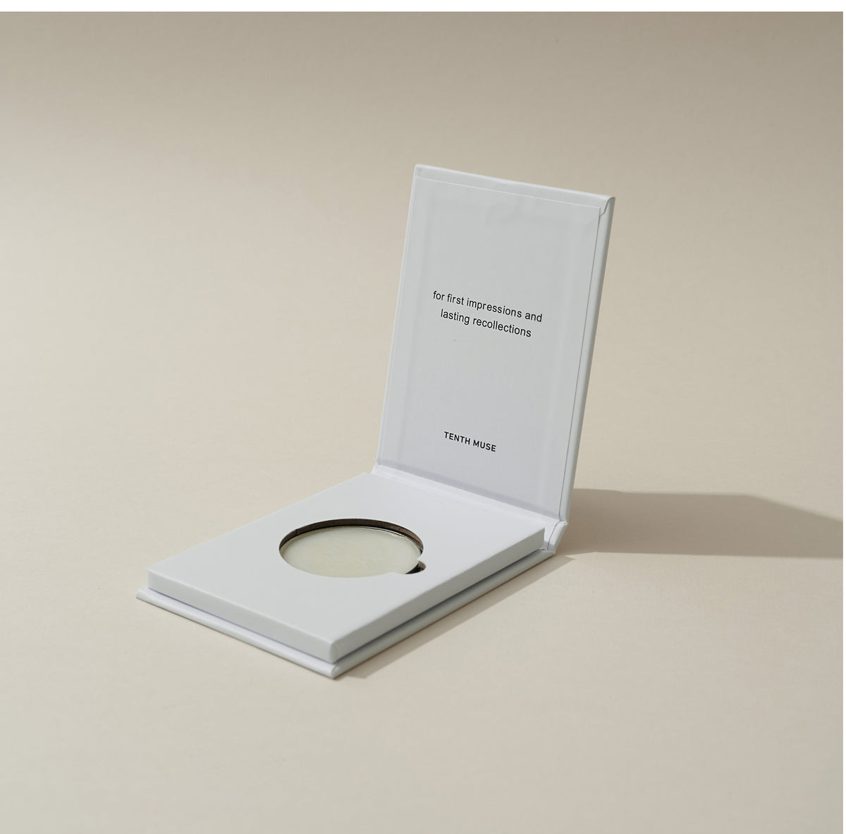 Tenth Muse 0.4 Clean Girl Solid Perfume in an open white compact on a beige background.