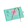 Cosmic Dealer Tongue Cleaner – teal box with rose gold cleaner, white background – oral care